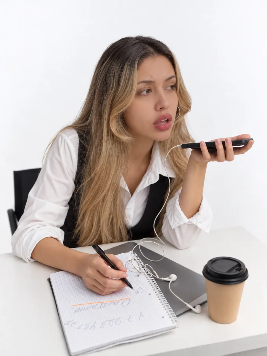 A call on speaker at the desk, the run of show going into a notebook