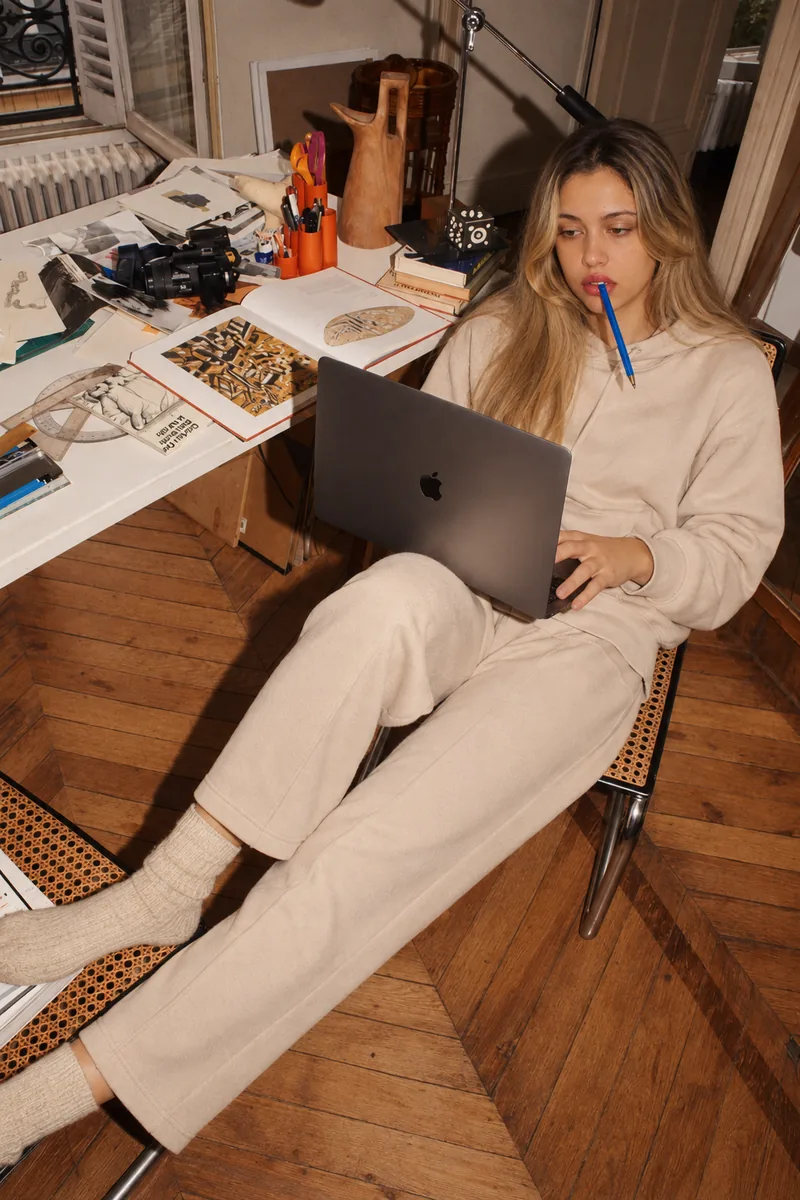 Working a laptop at a studio desk, pencil between the teeth