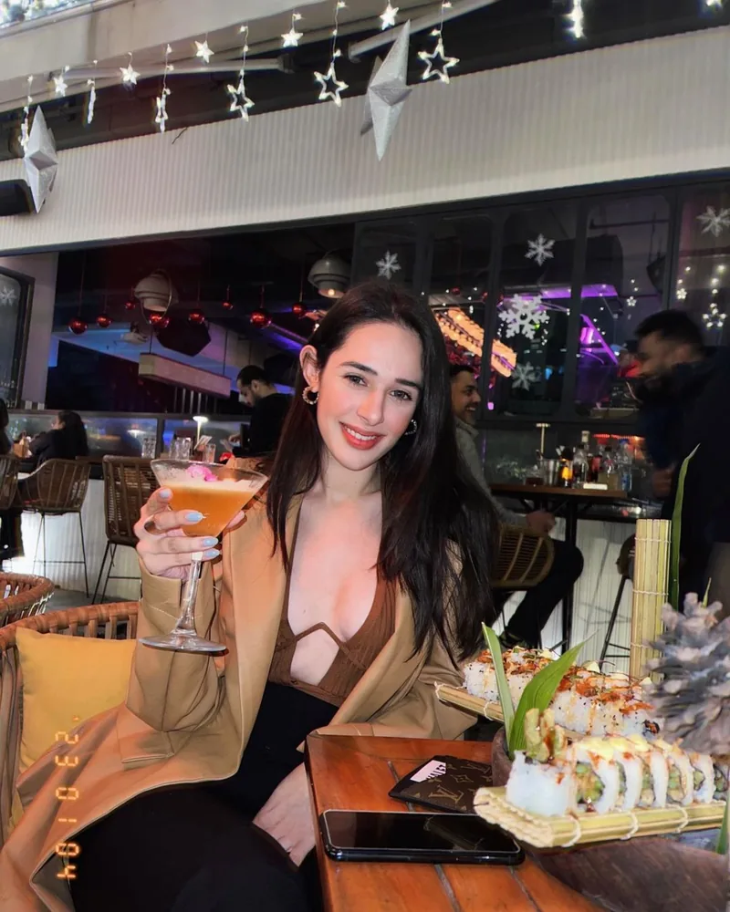 A creator with a cocktail and sushi